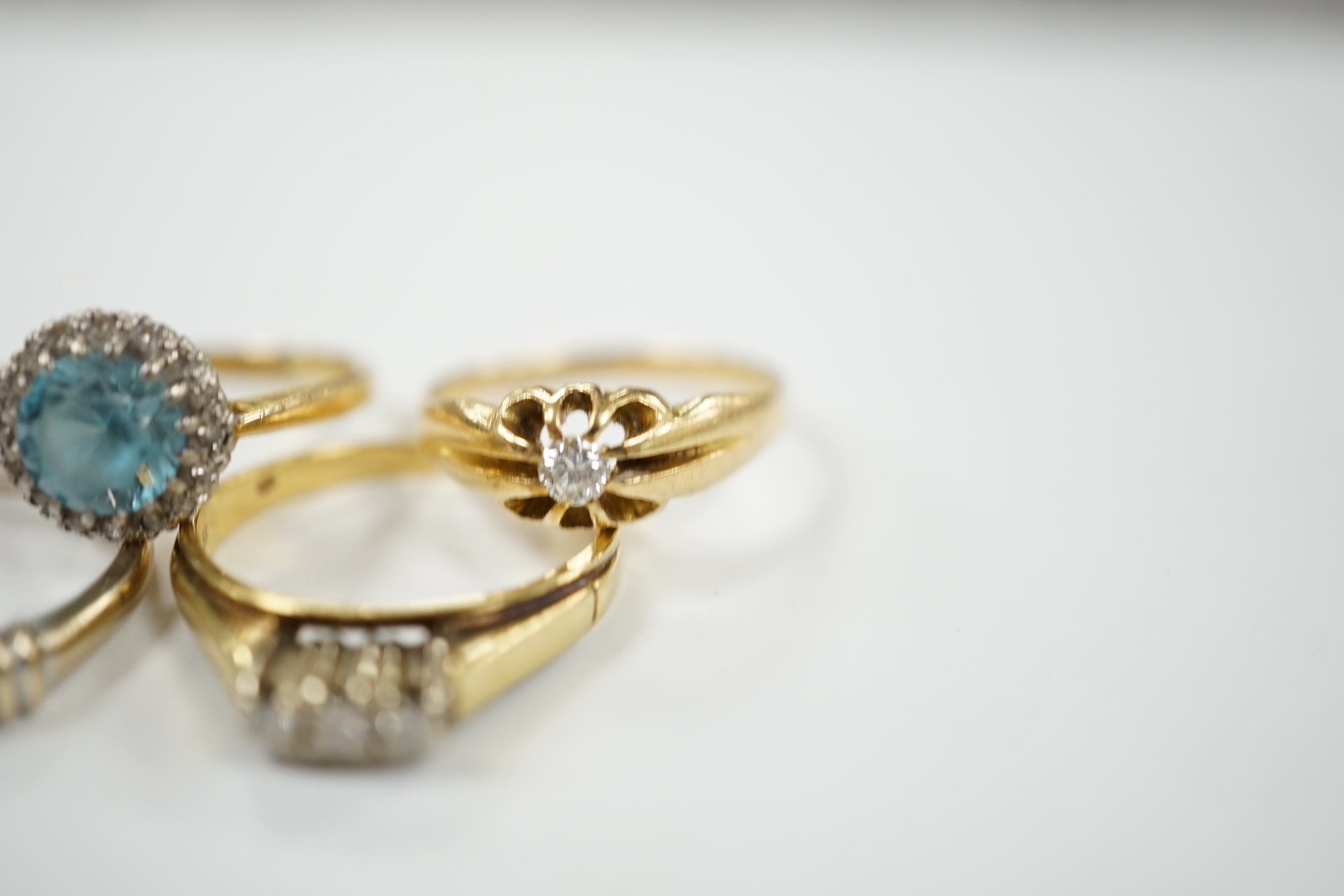 Three assorted 18ct and gem set dress rings, including blue zircon and diamond chip and claw set solitaire and one other yellow metal and gem set ring, gross weight 12.6 grams.